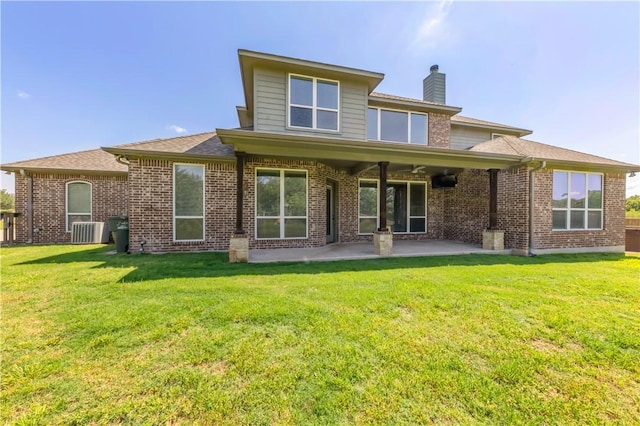 18214 Retriever Run, College Station, TX 77845 - rear view of house with a patio, a chimney, brick siding, and a lawn