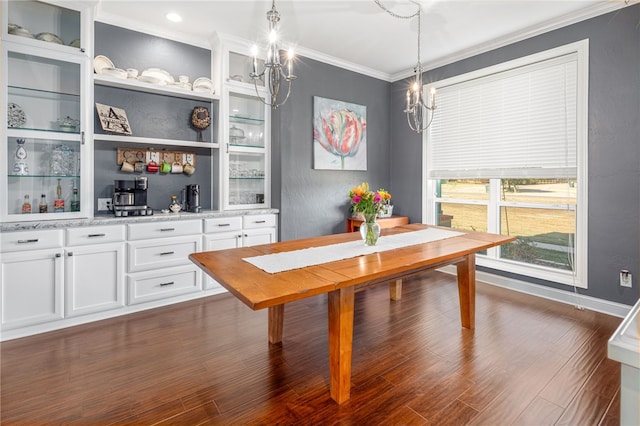 dining room with dark hardwood / wood-style floors, an inviting chandelier, and crown molding