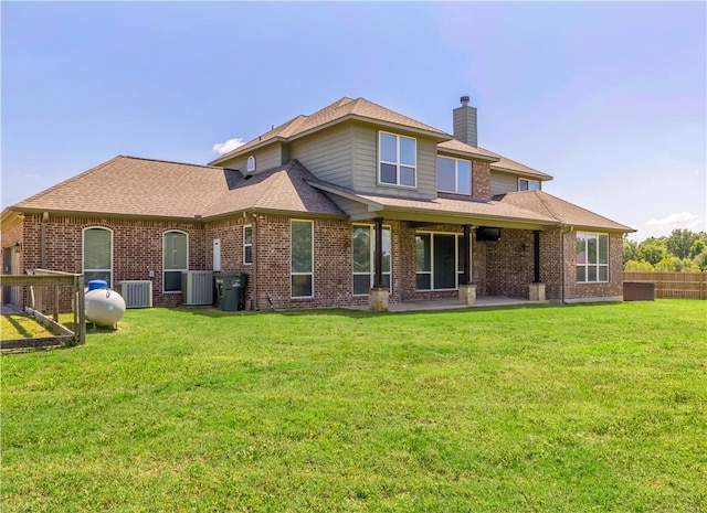 18214 Retriever Run, College Station, TX 77845 - rear view of house featuring central air condition unit, a chimney, and brick siding