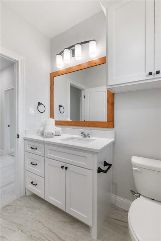 bathroom with marble finish floor, vanity, and toilet