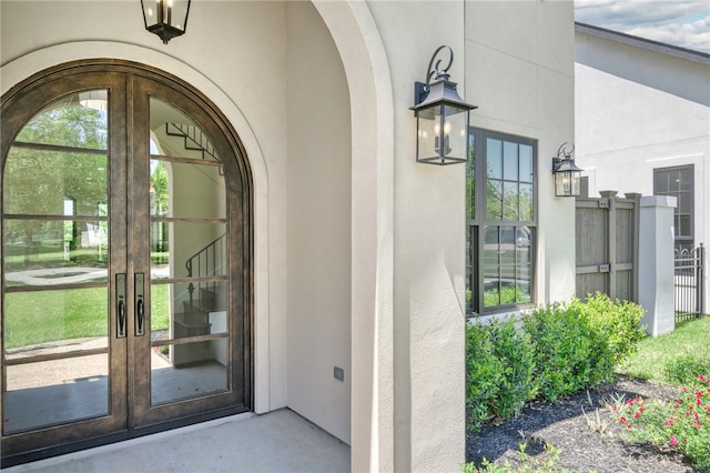 view of exterior entry featuring french doors and stucco siding