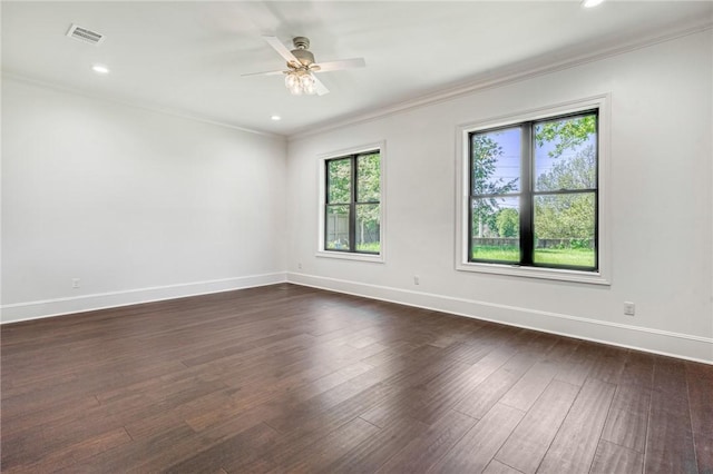 spare room featuring visible vents, baseboards, ornamental molding, a ceiling fan, and dark wood-type flooring