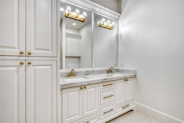 bathroom featuring tile patterned floors, double vanity, baseboards, and a sink