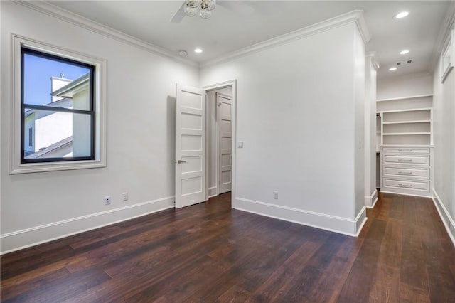 unfurnished bedroom featuring visible vents, baseboards, ornamental molding, a spacious closet, and wood finished floors