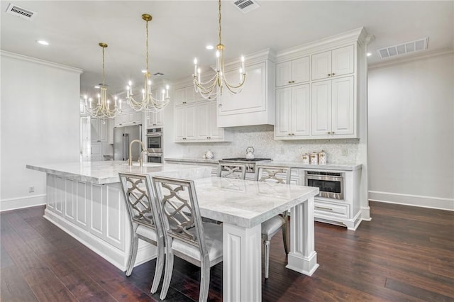 kitchen with a chandelier, appliances with stainless steel finishes, baseboards, and visible vents