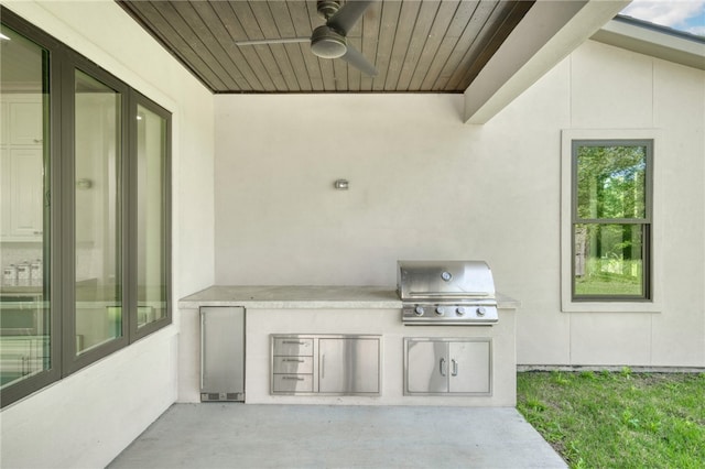 view of patio with grilling area, ceiling fan, and exterior kitchen