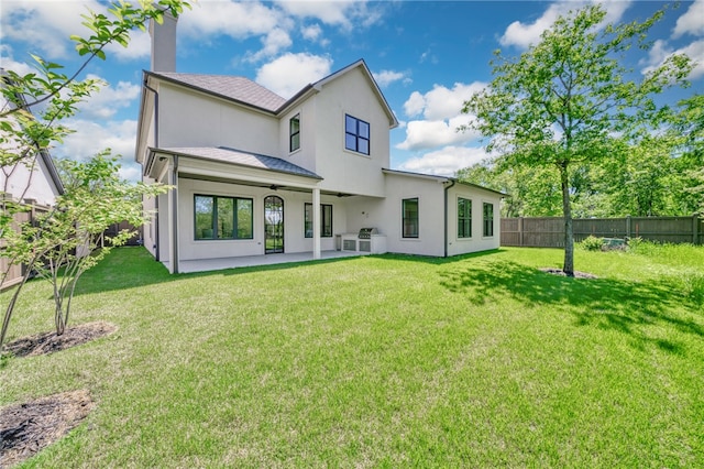 back of property featuring a fenced backyard, stucco siding, a patio area, and a lawn