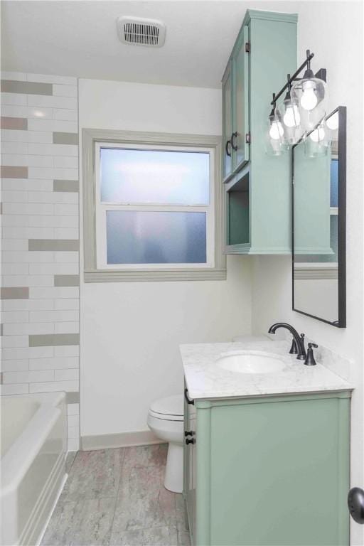 full bathroom with vanity, toilet, and tiled shower / bath