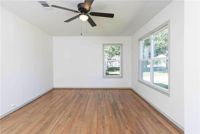 empty room with ceiling fan and hardwood / wood-style floors