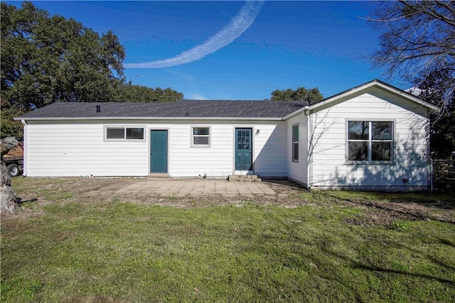 back of house with a lawn and a patio