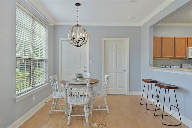801 Luther St W Unit 407, College Station, TX 77840 - dining room with light wood-type flooring, a chandelier, healthy amount of natural light, and crown molding