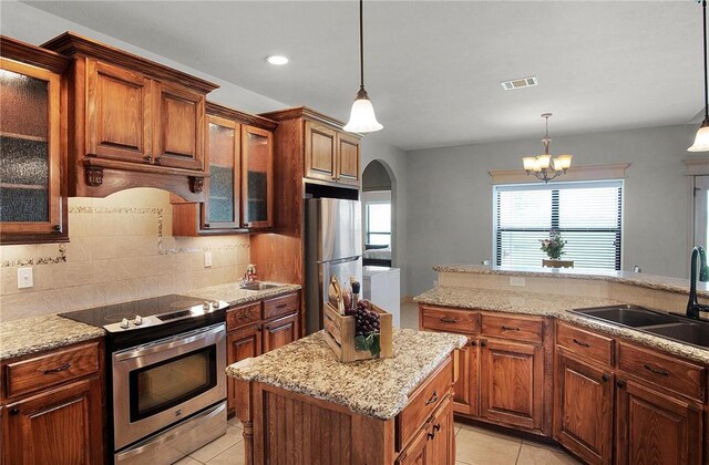 10175 Steep Hollow Rd, Bryan, TX 77808 - kitchen with stainless steel appliances, a sink, arched walkways, light tile patterned flooring, and backsplash