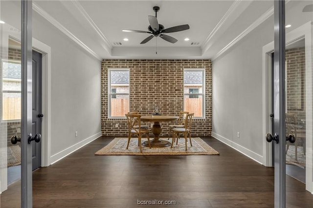 unfurnished dining area with a healthy amount of sunlight, dark wood-type flooring, and brick wall