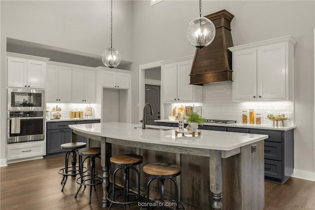 kitchen featuring white cabinets, decorative light fixtures, and sink