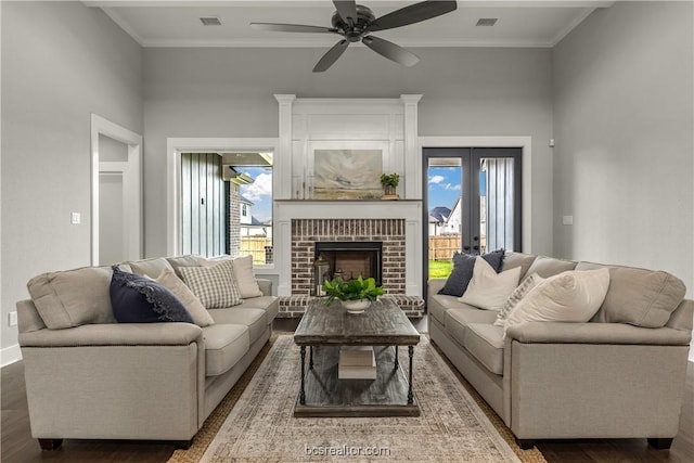 living room featuring dark wood-type flooring, crown molding, and a healthy amount of sunlight