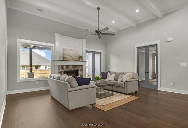 living room with french doors, dark hardwood / wood-style floors, ceiling fan, a fireplace, and beamed ceiling