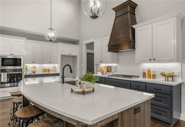 kitchen with white cabinetry, a kitchen island with sink, and appliances with stainless steel finishes