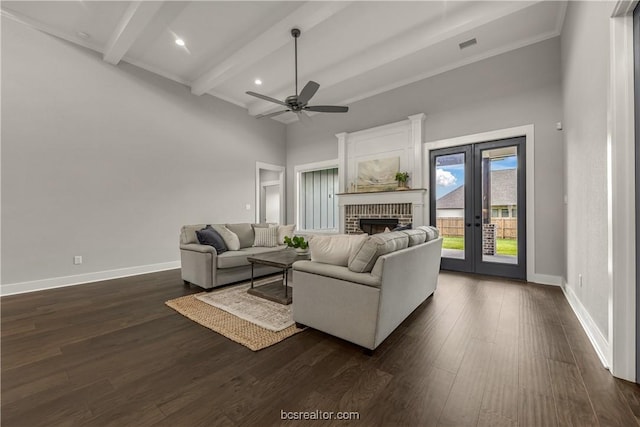 living room featuring ceiling fan, french doors, a brick fireplace, beamed ceiling, and dark hardwood / wood-style floors