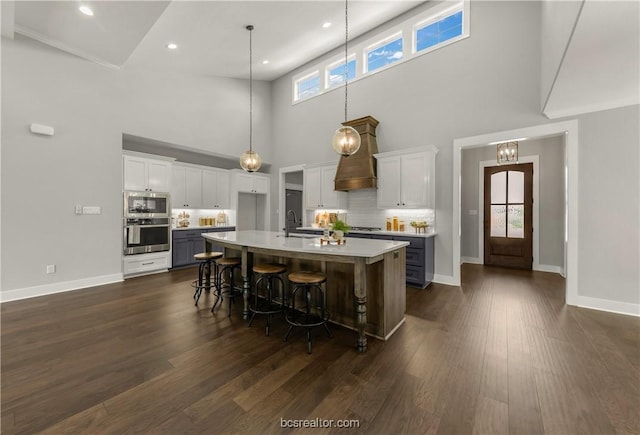 kitchen featuring appliances with stainless steel finishes, a center island with sink, a wealth of natural light, and a breakfast bar area