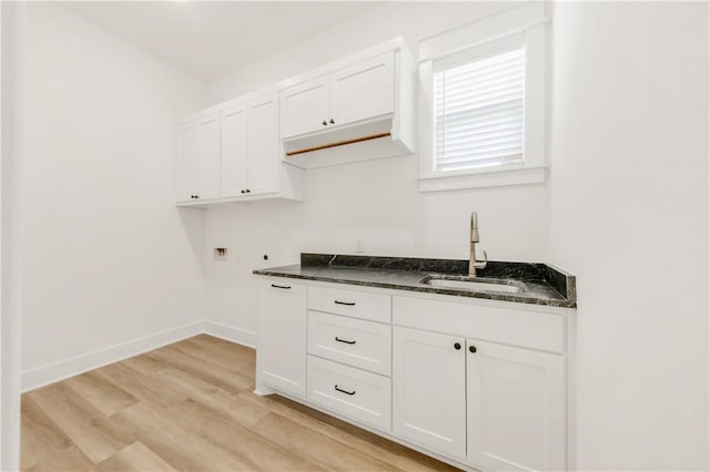 1701 Kerr Valley Ln, College Station, TX 77845 - laundry area featuring washer hookup, light wood-type flooring, and cabinet space