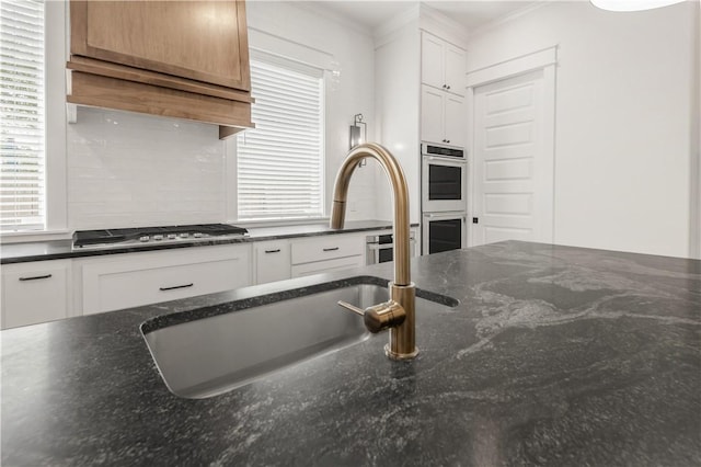 1701 Kerr Valley Ln, College Station, TX 77845 - kitchen featuring appliances with stainless steel finishes, white cabinetry, dark stone countertops, and crown molding