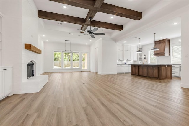 1701 Kerr Valley Ln, College Station, TX 77845 - unfurnished living room with ceiling fan, recessed lighting, beamed ceiling, light wood-type flooring, and a large fireplace