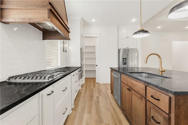 1701 Kerr Valley Ln, College Station, TX 77845 - kitchen with stainless steel appliances, light wood finished floors, custom exhaust hood, white cabinets, and ornamental molding
