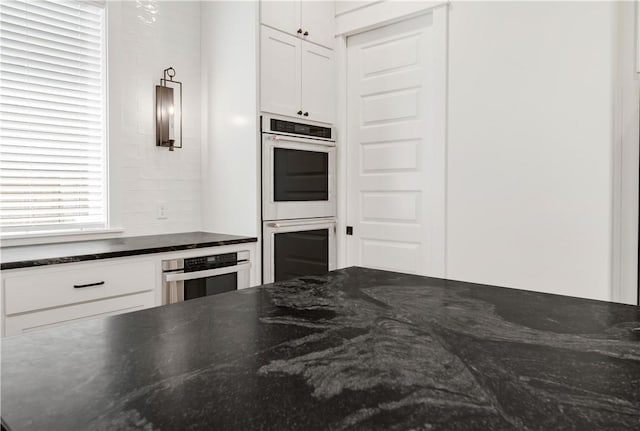 1701 Kerr Valley Ln, College Station, TX 77845 - kitchen with double oven, white cabinets, and dark stone countertops