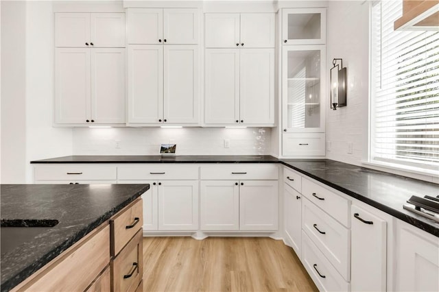 1701 Kerr Valley Ln, College Station, TX 77845 - kitchen with light wood finished floors, white cabinetry, dark stone counters, and glass insert cabinets