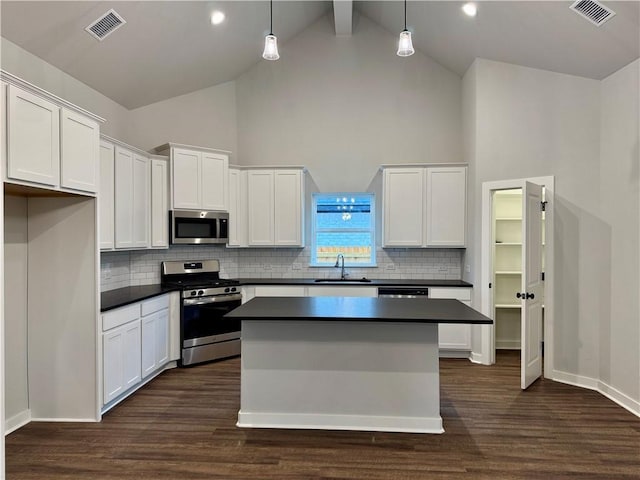 kitchen featuring sink, hanging light fixtures, dark hardwood / wood-style floors, white cabinetry, and stainless steel appliances