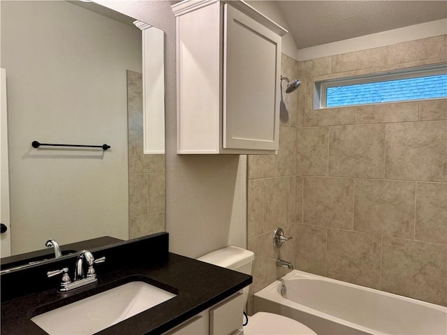 full bathroom featuring tiled shower / bath combo, a textured ceiling, vaulted ceiling, toilet, and vanity