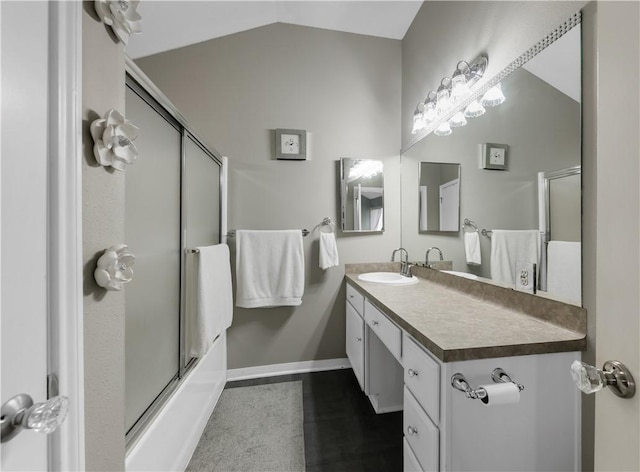 full bathroom with baseboards, vanity, lofted ceiling, and shower / bath combination with glass door