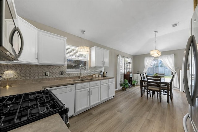 kitchen with freestanding refrigerator, a sink, white cabinets, light wood-style floors, and dishwasher