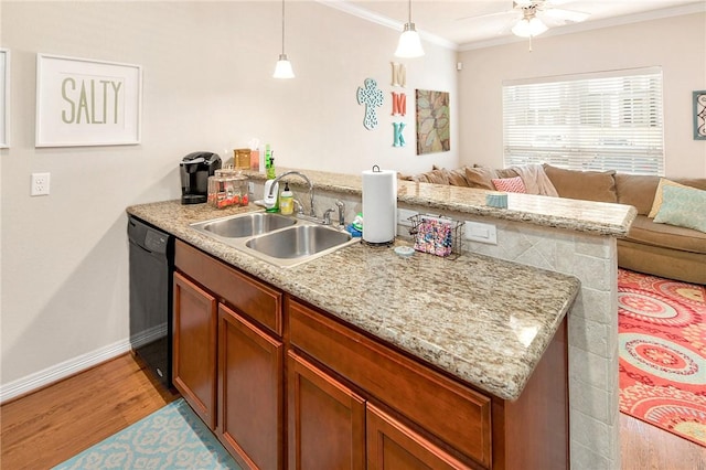 kitchen featuring light wood-type flooring, ornamental molding, sink, pendant lighting, and black dishwasher