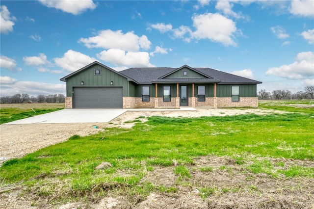 view of front of property with a garage, a front yard, concrete driveway, and brick siding