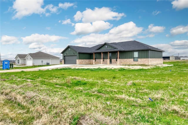 view of front of house featuring a garage, brick siding, concrete driveway, board and batten siding, and a front yard