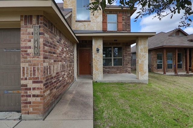 property entrance with a lawn and a patio area