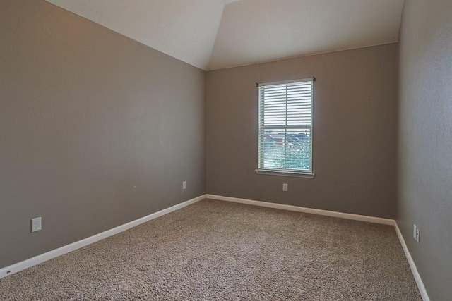 spare room with vaulted ceiling and carpet