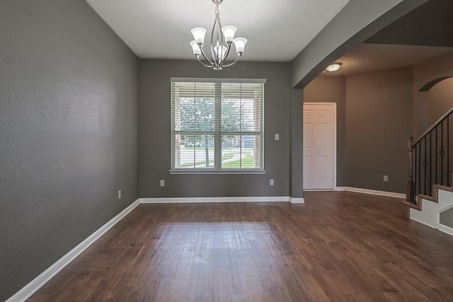 unfurnished dining area with an inviting chandelier and dark hardwood / wood-style floors