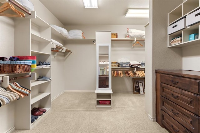 walk in closet featuring light colored carpet