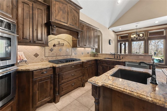 kitchen with black gas cooktop, double oven, pendant lighting, and a sink