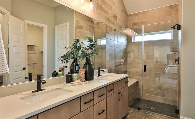 bathroom with tile patterned floors, a sink, a shower stall, and double vanity