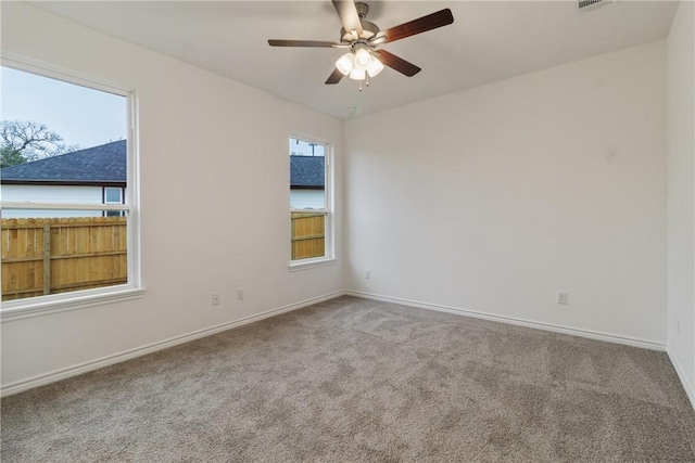 carpeted spare room featuring ceiling fan