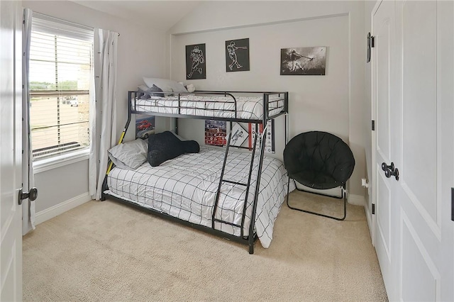 carpeted bedroom featuring vaulted ceiling and baseboards