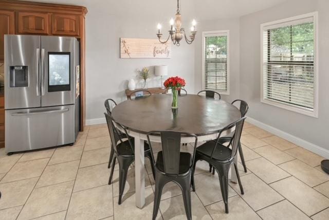 dining room featuring light tile patterned floors, a chandelier, and baseboards