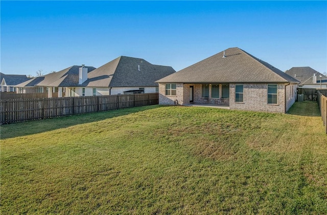 rear view of house featuring a yard