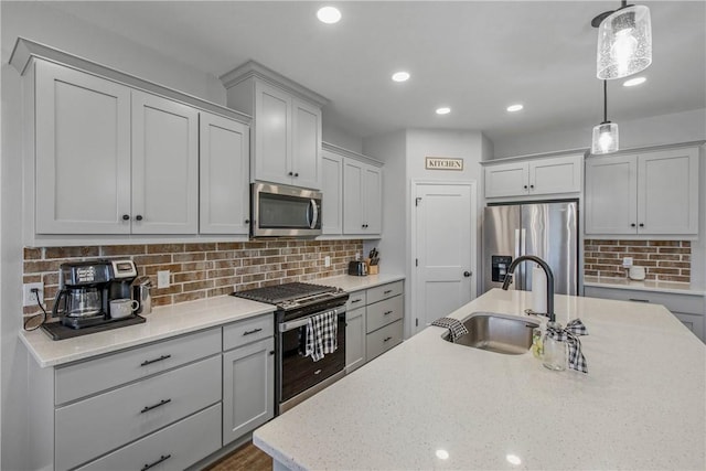 kitchen with sink, stainless steel appliances, decorative light fixtures, gray cabinets, and decorative backsplash