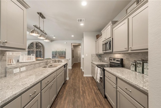 kitchen with visible vents, backsplash, dark wood finished floors, stainless steel appliances, and a sink