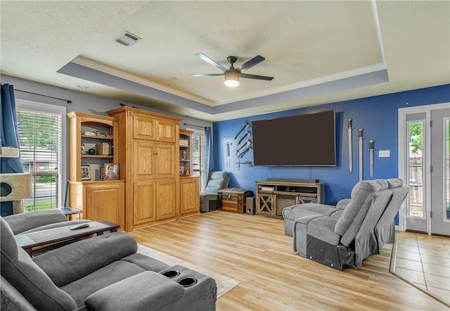 801 Camellia Ct, College Station, TX 77840 - living room featuring a tray ceiling, ceiling fan, crown molding, light wood-style floors, and a textured ceiling