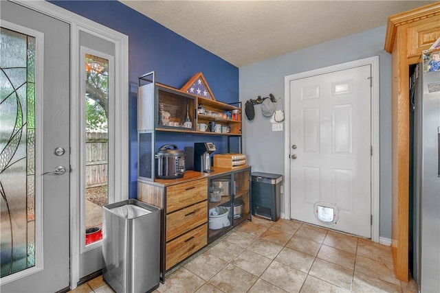 801 Camellia Ct, College Station, TX 77840 - entrance foyer with light tile patterned flooring, a textured ceiling, and baseboards